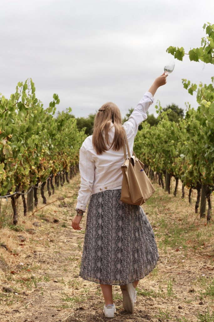 Outfit of the day in Sonoma and Napa valley in snakeskin midi skirt and white denim jacket with white Adidas Sleek Sneakers